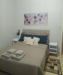 a bedroom with a large bed with towels on it at Casa Verde do Lago in São Francisco de Paula