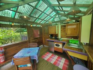 a kitchen with a table and a sink in a room at Heimanarii's Lodge - Fare Fetia in Haapiti