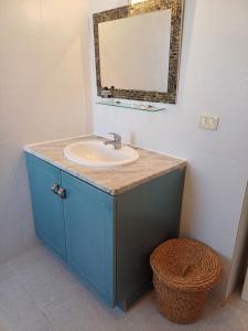 a bathroom with a sink and a mirror and a basket at Djerba Beach Haven in Aghīr +26 photos
