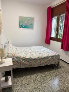 a bedroom with a bed in a room with pink curtains at Casa Calma in L'Escala +36 photos