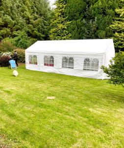 a white tent on a lawn in a yard at Pennygael in Lanark