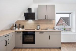 a kitchen with white cabinets and a sink at P & A Ferienwohnung in Soltau