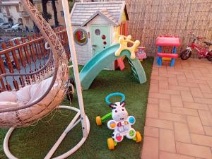 a childs play area with a playground and a swing at Garda City Home Family Apartments in Garda