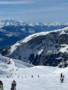 a group of people skiing down a snow covered mountain at Family friendly duplex with free parking in Leukerbad