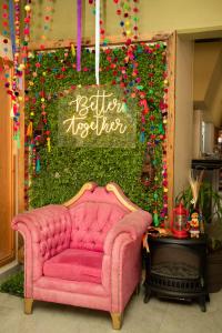 a pink couch in front of a wall with a sign at Hotel Uniko in San Cristóbal de Las Casas
