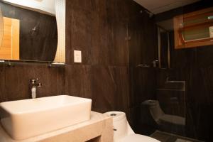 a bathroom with a white sink and a toilet at Hotel Uniko in San Cristóbal de Las Casas