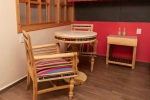 a bar with two chairs and a table and a stool at Hotel Uniko in San Cristóbal de Las Casas