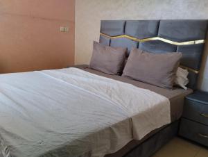 a bedroom with a large bed with a blue headboard at jardaine d'Ifrane in Ifrane