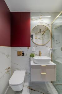 a bathroom with a toilet and a sink and a mirror at Pereca City Centre Studios by Arrenda in Warsaw +28 photos