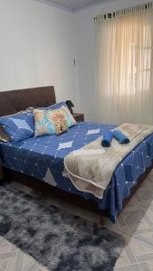 a bed with a blue comforter in a room at House on Hermenegildo Beach in Santa Vitória do Palmar