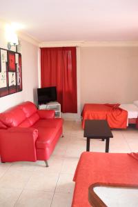 a living room with a red couch and a bed at Hacienda Blue Bay in Mazatlán