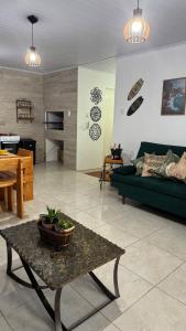 a living room with a green couch and a table at House on Hermenegildo Beach in Santa Vitória do Palmar