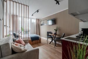 a living room with a couch and a table at Pereca City Centre Studios by Arrenda in Warsaw