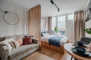 a living room with a bed and a couch at Pereca City Centre Studios by Arrenda in Warsaw