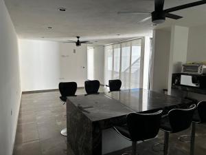 a living room with a table with chairs and a ceiling fan at Otoch de Paz in Cholul