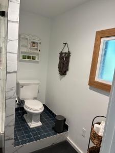 a bathroom with a toilet and a window at Painted sky casita in San Diego +12 photos