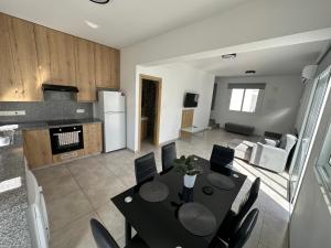 a kitchen and living room with a table and chairs at Ocean Breeze 2BR House in Paralimni +7 photos