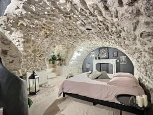a bedroom with a bed in a stone wall at L'epicurisme in Lorgues