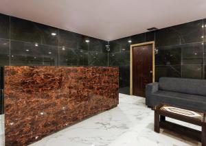 a living room with a stone wall and a couch at Super Capital O Che Sigma Hotel in Hyderabad