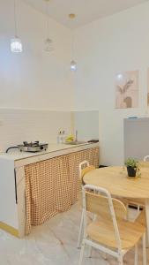a kitchen with a wooden table and a table and chairs at DM Guesthouse - Impasugong Bukidnon in Impasugong