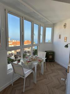a dining room with a table and chairs and windows at Cozy Studio with Seaview in Costa Del Silencio