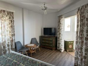 a bedroom with a bed and a tv and a table at Cozy Studio with Seaview in Costa Del Silencio