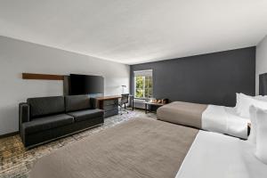 a hotel room with a bed and a couch at Quality Inn & Suites Manhattan in Manhattan