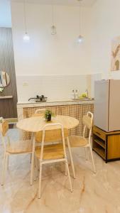 a kitchen with a table and chairs and a refrigerator at DM Guesthouse - Impasugong Bukidnon in Impasugong
