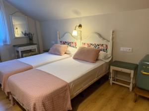 a bedroom with two beds and a mirror at Edelweiss Hotel in Torla-Ordesa