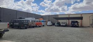 a group of old cars parked in a parking lot at Cesare in Uyuni