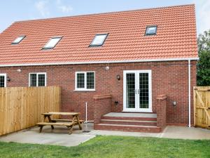 a brick house with a bench and a wooden fence at Dawson Park 9 - Uk12668 in Mablethorpe