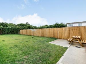 a backyard with a wooden fence and a picnic table at Dawson Park 9 - Uk12668 in Mablethorpe
