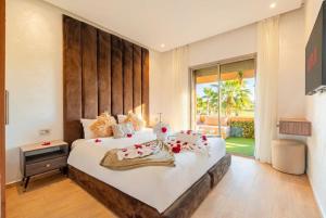 a bedroom with a large bed with towels on it at Prestigia Family Luxury Apartments in Marrakesh +233 photos