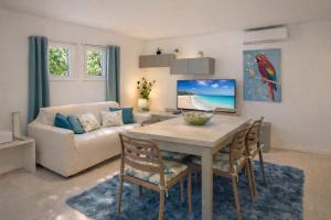 a living room with a table and a couch at Villa Greif Pineta Apartment in Lignano Sabbiadoro