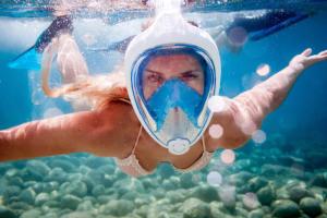a woman is swimming in the water with a bottle at Mountain Chalet with Awesome Sea View in Loma Partida