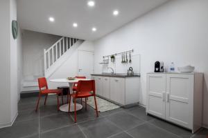 a kitchen with red chairs and a table and a staircase at Aduepassi in Mirabella Imbaccari
