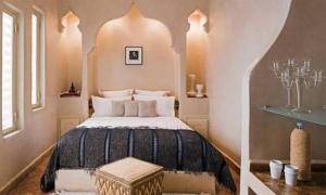 a bedroom with a large bed with an arched ceiling at Gust hotel in Marrakesh