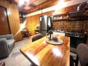a kitchen with a wooden table and a refrigerator at Espacio Calma in Valdivia