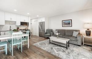a living room with a couch and a table and a kitchen at Modern Style Third Floor Condo with Private Balcony in Bend