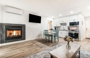 a living room with a fireplace and a table at Modern Style Third Floor Condo with Private Balcony in Bend