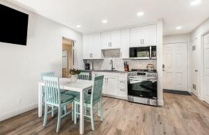 a kitchen with white cabinets and a table and chairs at Modern Style Third Floor Condo with Private Balcony in Bend +33 photos