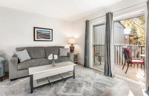 a living room with a couch and a table at Modern Style Third Floor Condo with Private Balcony in Bend