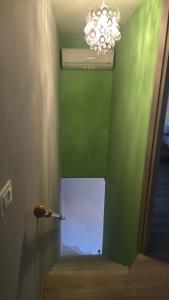 a room with a green wall and a chandelier at Seravale in Serravalle