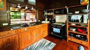 a kitchen with a stove and a microwave at TAHITI - PK18 Beach Cottage in Punaauia +22 photos
