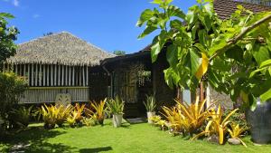 an exterior view of a house with a garden at TAHITI - PK18 Beach Cottage in Punaauia