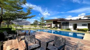 a patio with chairs and a swimming pool at Suite Talie Cebu Cozy Modern Stay with Pool & Netflix in Lapu Lapu City