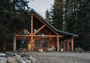 a log cabin in the woods with trees at Grizzly Den in Valemount