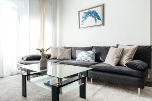 a living room with a black couch and a glass table at Brilliant 2BD condo in Los Angeles
