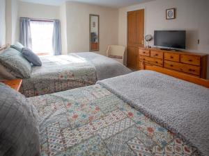 a hotel room with two beds and a television at The Bridge Inn Apartment in Bridgerule