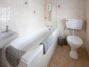a bathroom with a tub and a toilet and a sink at The Bridge Inn Apartment in Bridgerule +6 photos